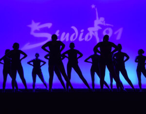 2022 June show dancers silhouetted against dark blue background